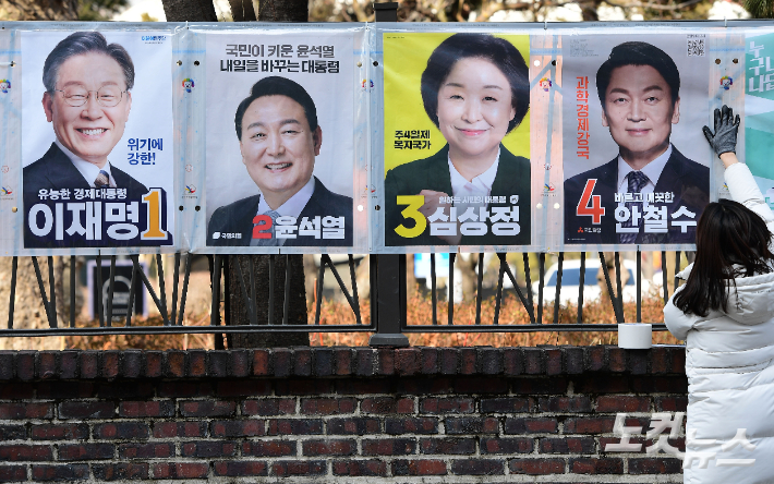지난달 18일 오후 종로구선관위 관계자들이 서울 종로구 예술의 집 울타리에 20대 대선 후보 벽보를 부착하고 있다. 황진환 기자