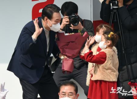 윤석열 국민의힘 대선 후보가 7일 경기 안양 평촌중앙공원에서 열린 유세에서 아이들에게 꽃다발을 받고 인사하고 있다.