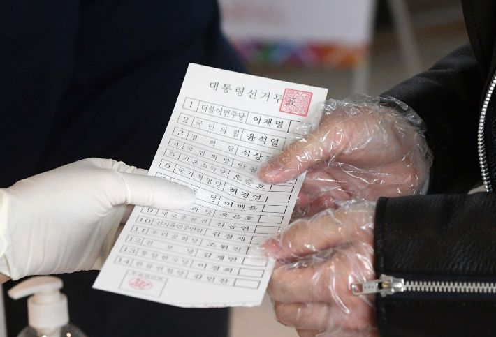 제20대 대통령선거 투표일인 9일 오전 서울 광진구 한아름쇼핑센터에 마련된 화양동 제5투표소에서 유권자가 투표용지를 받고 있다. 이한형 기자