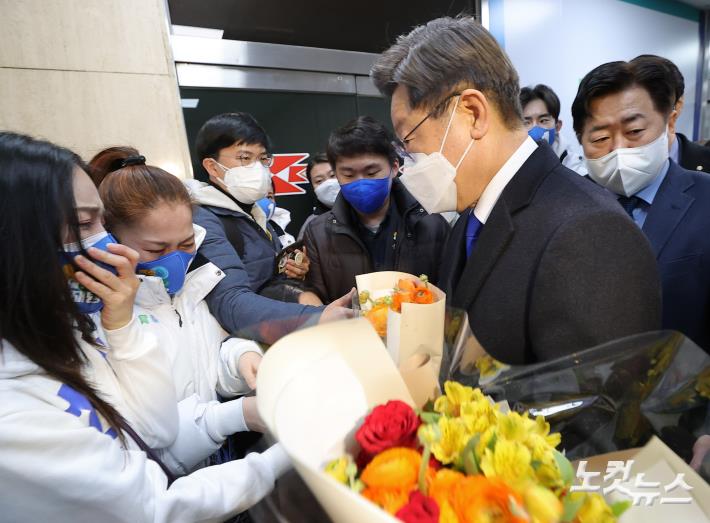 '지지자들로부터 꽃다발 전달받는 이재명