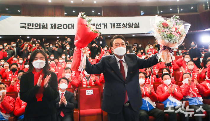 윤석열 대통령 당선인이 10일 새벽 서울 여의도 국회도서관에 마련된 '국민의힘 제 20대 대통령선거 개표상황실'을 찾아 축하의 꽃다발을 받아들고 있다. 윤창원 기자