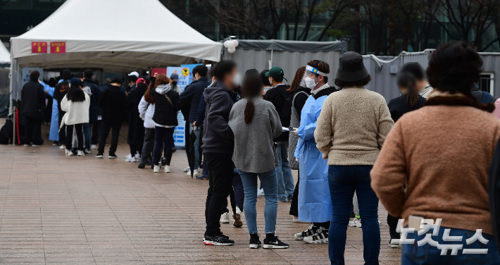 코로나19 신규확진자가 35만 190명을 기록한 13일 오전 서울광장에 마련된 선별진료소에서 시민들이 검사를 받기 위해 대기하고 있다. 황진환 기자