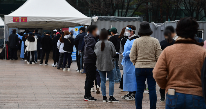 코로나19 신규확진자가 35만 190명을 기록한 13일 오전 서울광장에 마련된 선별진료소에서 시민들이 검사를 받기 위해 대기하고 있다. 황진환 기자