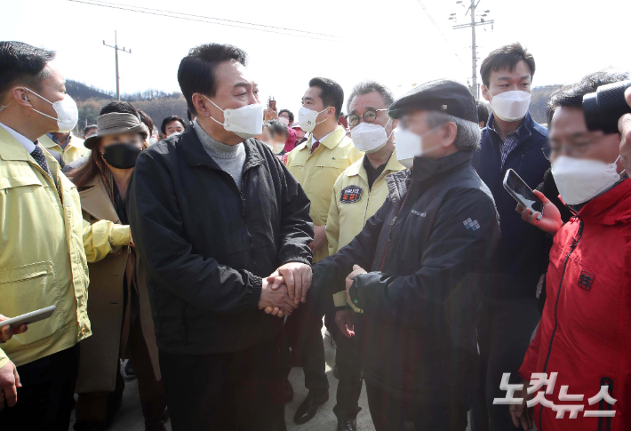 윤석열 대통령 당선인이 15일 경북 울진군 북면 검성리 산불피해현장을 방문해 피해지역 주민들과 인사하고 있다. 국회사진취재단