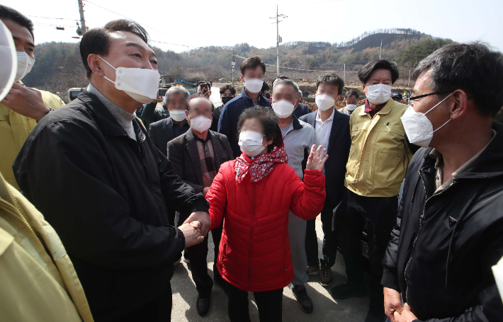 윤석열 대통령 당선인이 15일 경북 울진군 북면 검성리 산불피해현장을 방문해 피해지역 주민들과 인사하고 있다. 국회사진취재단