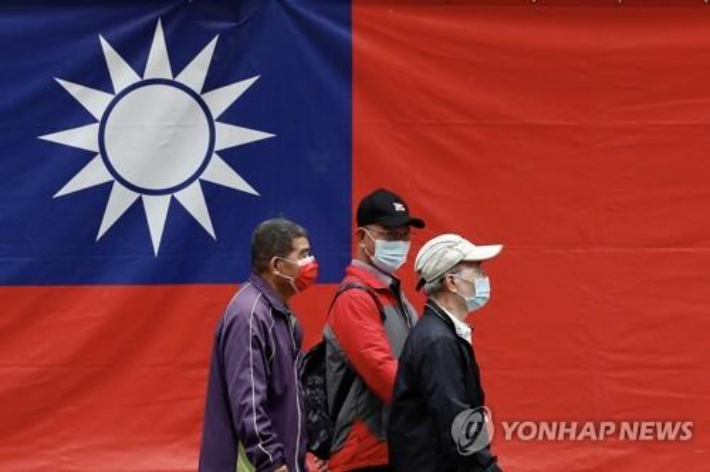 대만 타이베이 거리에서 시민들이 국기인 청천백일기 앞을 걸어가고 있다.  연합뉴스