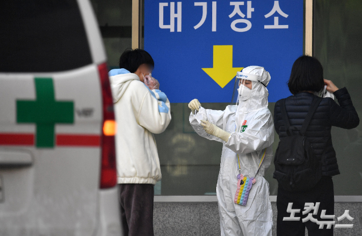 의료진이 코로나19 환자에게 마스크를 교체 착용시키고 있다. 박종민 기자