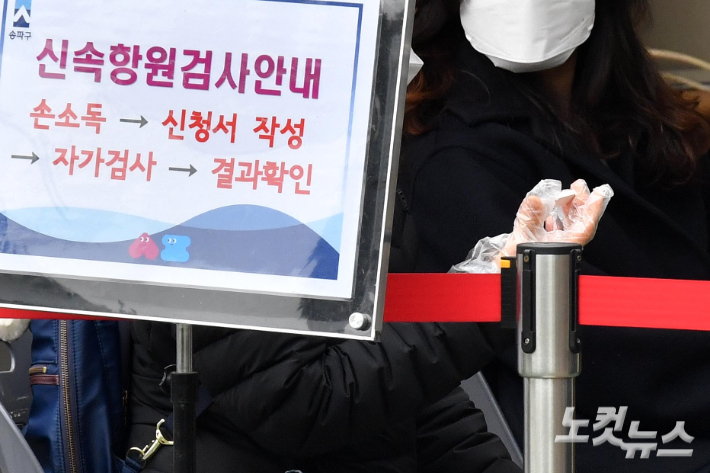 코로나19 누적 확진자가 1000만 명선을 넘어선 23일 서울 송파보건소에 마련된 선별진료소를 찾은 시민이 신속항원검사 결과를 기다리고 있다. 박종민 기자