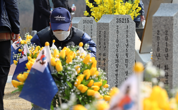 서해수호의 날을 하루 앞둔 24일 오후 국립대전현충원 천안함 46용사 묘역에서 유족이 슬픔에 잠겨 있다. 연합뉴스