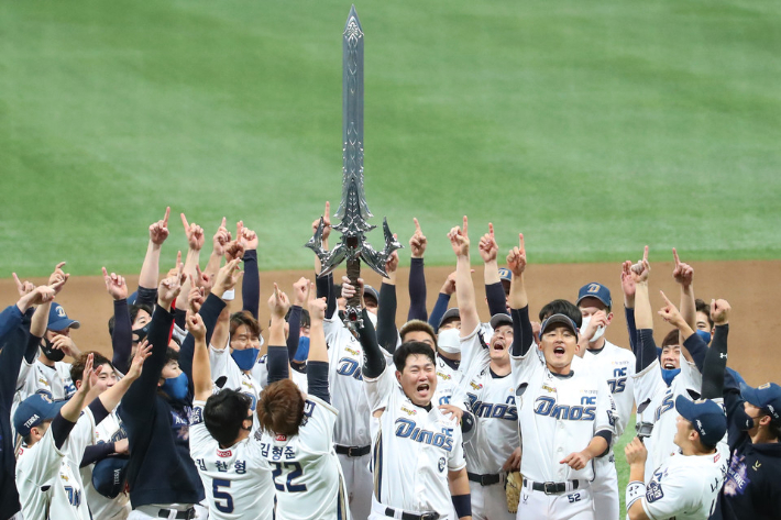 우승을 차지한 NC 다이노스 선수들이 모기업 NC소프트의 온라인게임 리니지의 집행검을 들어 올리며 승리를 자축하고 있다. 연합뉴스