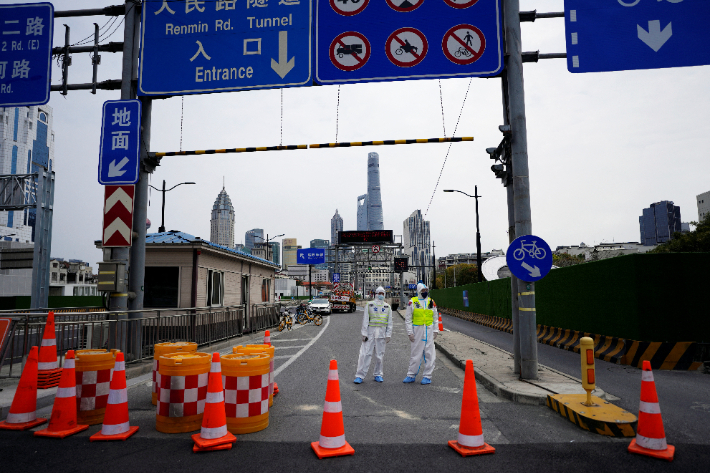 코로나19 봉쇄령이 내려진 중국의 '경제수도' 상하이에서 28일 보호복을 입은 경찰이 황푸강을 건너 푸둥신구로 통하는 터널 통행을 통제하고 있다. 연합뉴스
