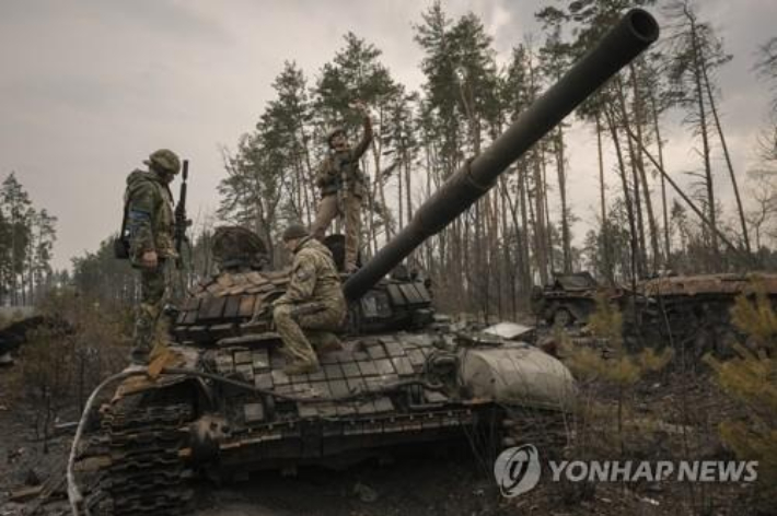  우크라이나 수도 키이우(키예프) 외곽에서 지난달 31일(현지시간) 우크라이나 병사가 파괴된 러시아군 탱크 위에 올라 '셀카'를 찍고 있다. 연합뉴스