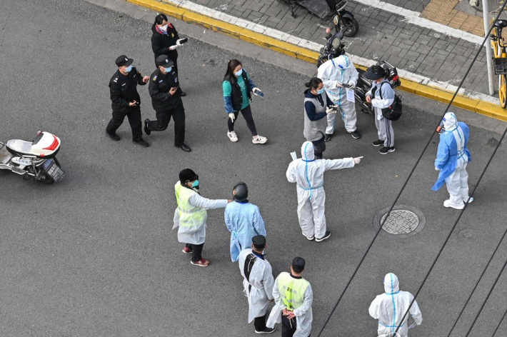 봉쇄된 중국 상하이시에서 방역 요원들이 거리에서 시민들을 안내하는 모습. 연합뉴스