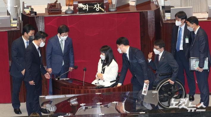 5일 오후 국회에서 열린 본회의가 끝난 뒤 박병석 국회의장과 더불어민주당 최혜영 의원, 국민의힘 이종성 의원 등 휠체어를 탄 장애인 의원들이 본회의장에서 발언할 수 있도록 새로 설치된 연설대(좌우 상하 높이 조절 가능)를 시연하고 있다.