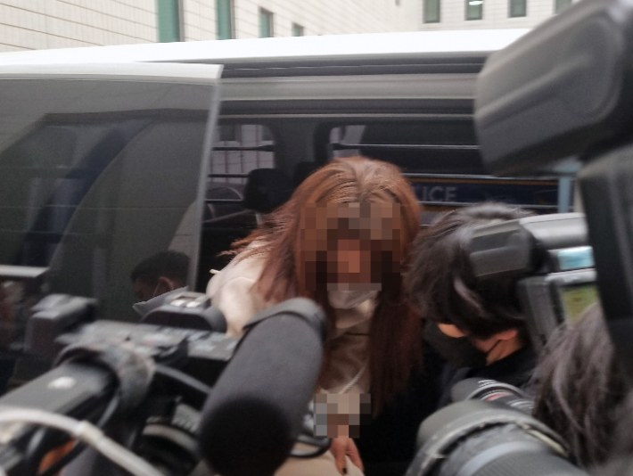  9호선 휴대전화 폭행 사건으로 구속된 20대 여성이 지난달 30일 오전 서울 강서경찰서 호송차에서 내리고 있다. 연합뉴스
