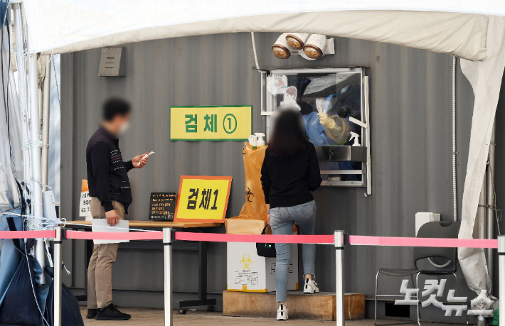 코로나19 신규 확진자가 9만 928명 발생한 11일 서울광장에 마련된 선별진료소에서 시민들이 PCR검사를 받고 있다. 신규 확진자 수가 10만 명 밑으로 내려온 건 지난 2월 22일 이후 48일 만이다. 황진환 기자
