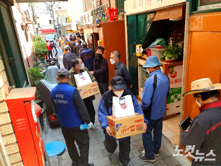 서울 돈의동 쪽방촌 주민들이 '나눔키트'를 받고 돌아가고 있다.