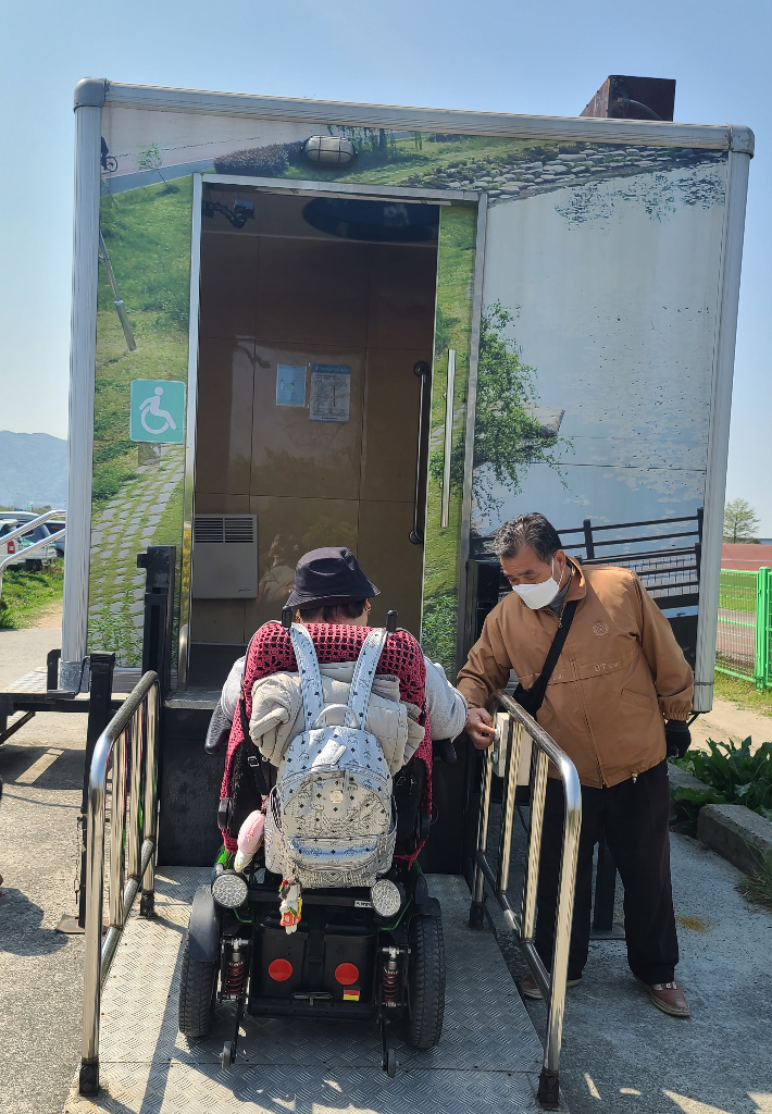 19일 부산 삼락생태공원의 한 화장실에서 장애인 단체가 휠체어 리프트가 제대로 작동하지 않는 모습을 시연하고 있다. 사상구장애인자립생활센터 제공