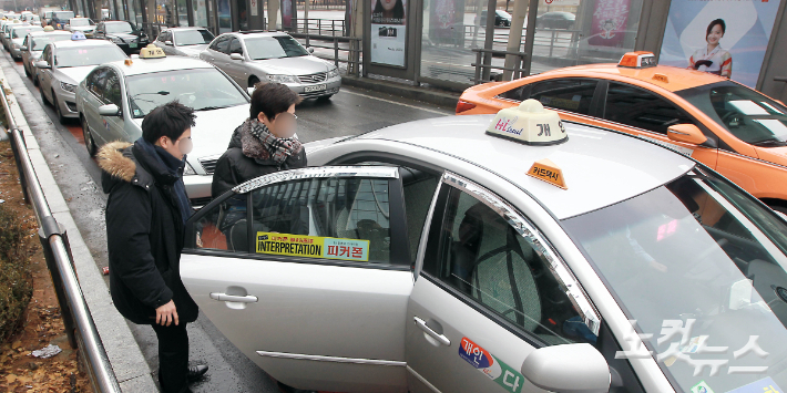 택시 승강장에서 택시에 승차하는 승객들. 