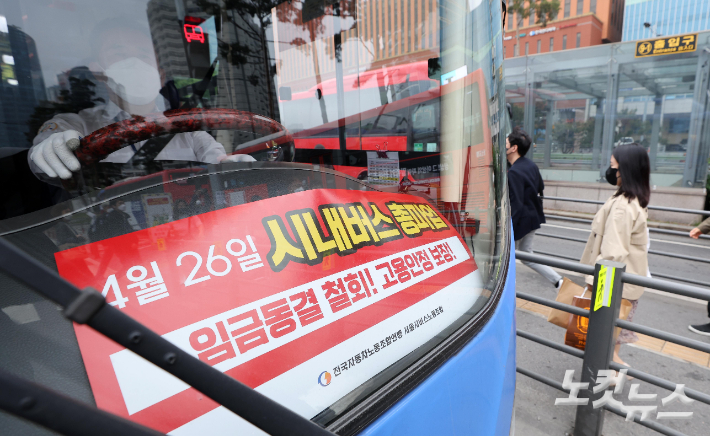 서울시버스노조가 예고한 총파업을 하루 앞둔 지난 25일 서울역 버스환승센터를 지나는 서울 시내버스 전면에 총파업 관련 피켓이 놓여 있다. 박종민 기자