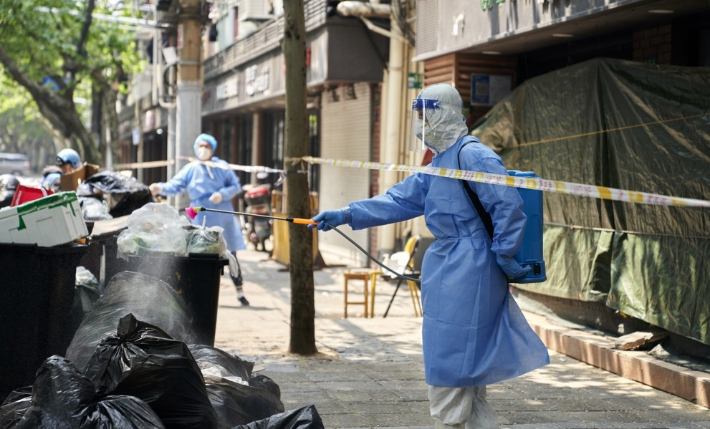 중국 상하이에서 개인보호장비를 착용한 방역 요원들이 쓰레기봉투 더미를 소독하고 있다. 연합뉴스