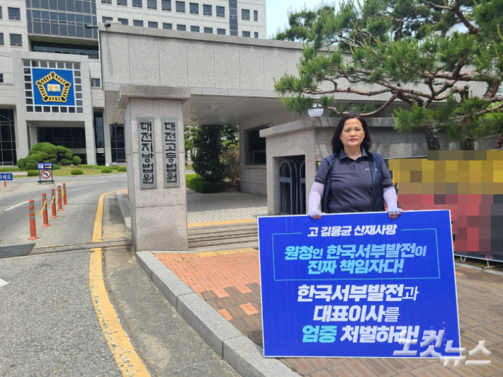 고(故) 김용균 노동자의 어머니 김미숙씨가 11일 대전지방법원 앞에서 책임자 처벌을 촉구하는 피켓을 들고 있다. 김정남 기자