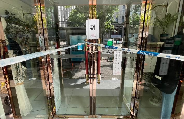 봉쇄된 중국 상하이의 한 옷가게의 문에 봉인 스티커가 붙어 있다. 상하이의 상점들은 이르면 3월 초중순부터 운영 중단 지시를 받아 두 달 넘게 장사를 하지 못하고 있어 많은 중소기업과 자영업자들이 존폐 위기에 몰린 상태다. 연합뉴스