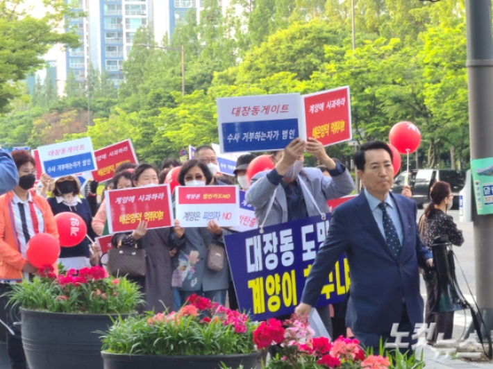 지난 18일 인천 계양구 오조산공원에서 열린 '이재명 후보 낙선운동 집회' 참가자들이 손팻말을 들고 행진하는 모습. 주영민 기자