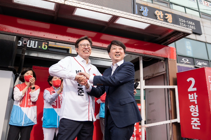 23일 오후 부산 구포시장에서 열린 유세에서 이준석 국민의힘 대표와 박형준 부산시장 후보가 손을 맞잡고 있다. 박형준 후보 선대위 제공