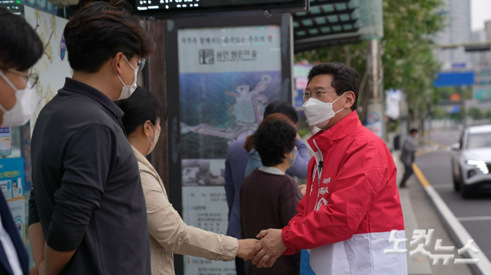 이상일 후보가 정류장에서 버스를 기다리는 유권자들과 인사를 나누고 있다. 박철웅 PD