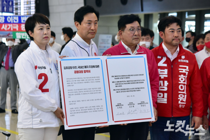 국민의힘 오세훈 서울시장·김은혜 경기지사·허향진 제주지사 후보와 부상일 제주을 후보가 30일 오후 서울 강서구 김포공항 국내선 청사에서 공동 기자회견 열고 '김포공항 이전, 국내선 폐지 주장에 따른 공동대응 협약서'에 서명하고 들어보이고 있다. 윤창원 기자