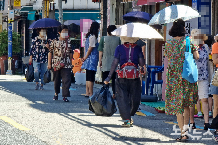 6일 부산지역은 낮 기온이 35.6도까지 올라 올해 최고 기온을 기록했다. 부산 남구 한 전통시장에 나온 시민들이 양산을 쓰고 있다. 송호재 기자