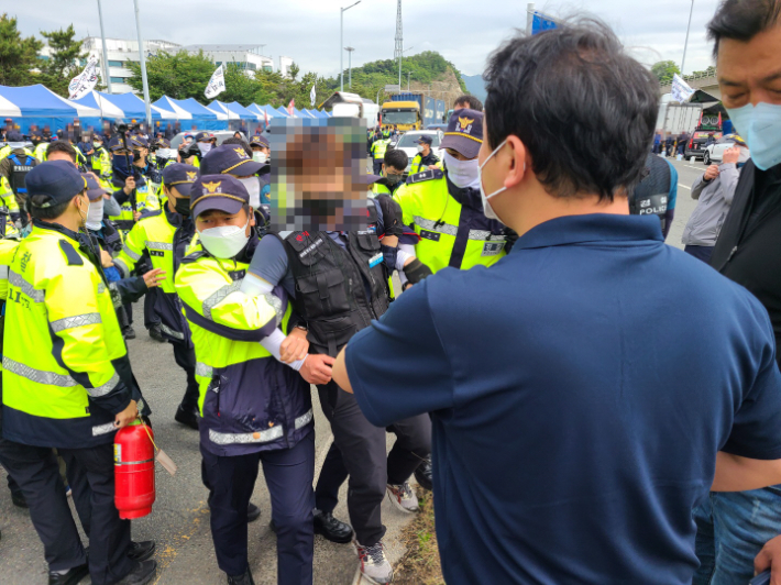 8일 부산신항 삼거리에서 트레일러 운행을 방해한 혐의로 화물연대 조합원이 연행되고 있다. 부산경찰청 제공