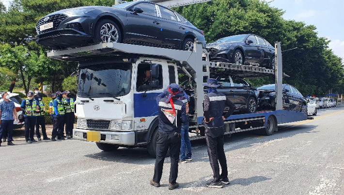 8일 오후 충남 아산현대자동차 출고장 앞 도로에서 화물연대 소속 노조원들이 완성차를 싣고 나오는 화물차를 막고 파업 당위성을 설명하고 있다. 연합뉴스