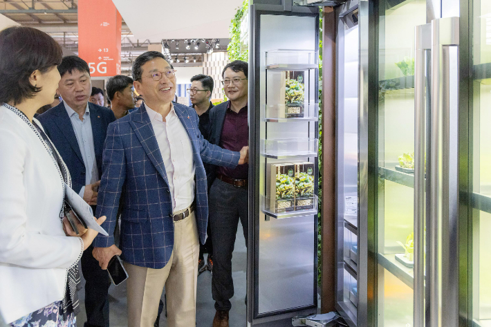 LG전자 조주완 사장(가운데)이 이탈리아에서 열리는 '밀라노 디자인 위크 2022'에서 고객경험 혁신을 위한 경영 행보를 펼쳤다. 조주완 사장이 LG전자 전시부스를 찾아 식물생활가전 컨셉 제품을 살펴보고 있다. LG전자 제공.