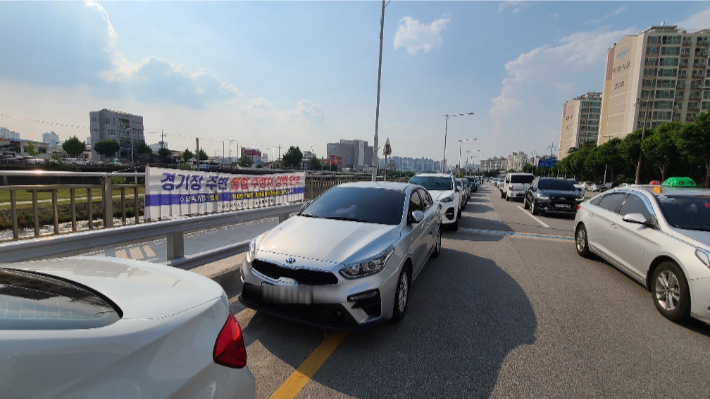 지난 11일 광주 북구 광주기아챔피언스필드 인근 천변 도로에 불법 주차된 차량들. 김한영 기자