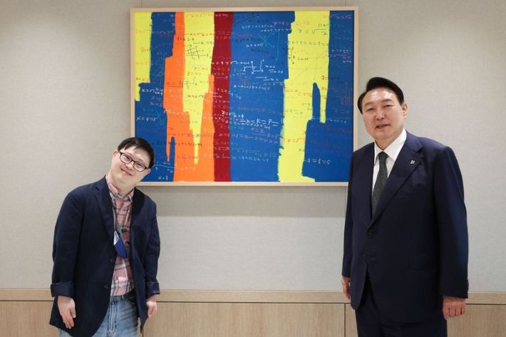 윤석열 대통령이 17일 용산 대통령 집무실에 걸린 그림을 그린 발달장애 화가인 김현우 작가와 만나 기념촬영을 하고 있다. 대통령실 제공 