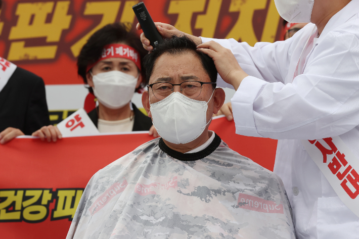 최광훈 대한약사회장이 19일 오후 서울 용산구 대통령 집무실 인근 전쟁기념관 앞에서 열린 약 자판기 저지를 위한 전국 약사 결의대회에서 촉구하며 삭발하고 있다. 연합뉴스