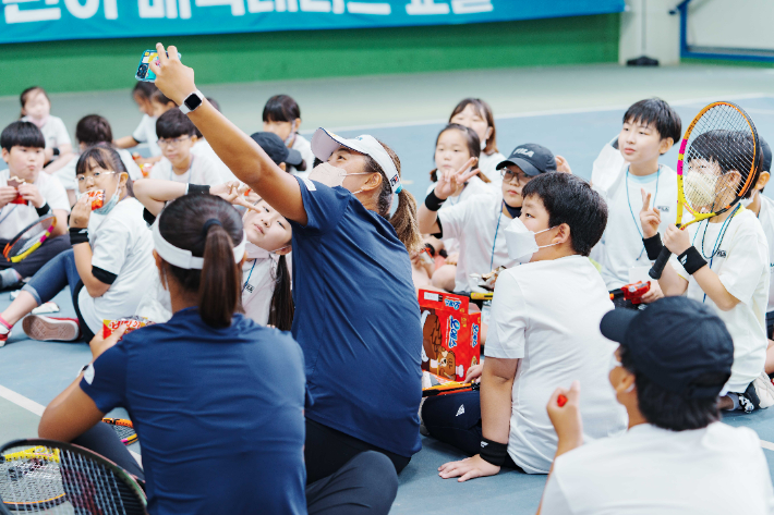 NH농협은행 테니스팀 선수들이 울릉도 지역 초등학교 학생들에게 재능 기부 행사를 펼치는 모습. NH농협은행