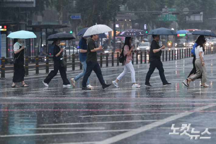본격적으로 장마가 시작된 23일 오후 서울 광화문네거리에 우산을 쓴 시민들이 발걸음을 옮기고 있다. 류영주 기자