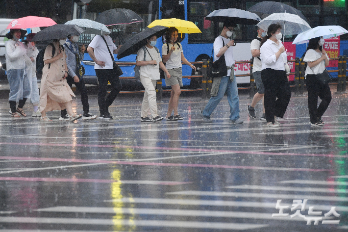 본격적으로 장마가 시작된 23일 오후 서울 광화문네거리에 우산을 쓴 시민들이 발걸음을 옮기고 있다. 류영주 기자