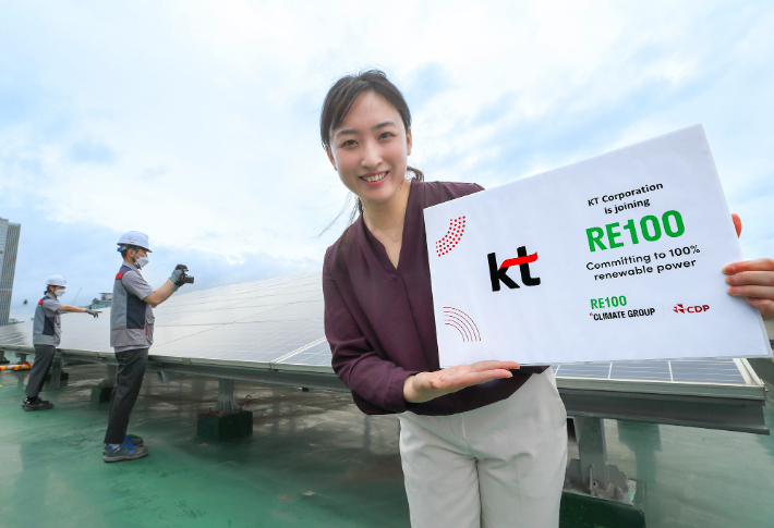 관악구 KT구로타워 옥상에 구축된 태양광발전소에서 KT 직원이 RE100 가입을 알리는 기념사진을 촬영하는 모습. KT 제공