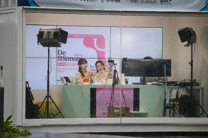 한국왕홍 다나(왼쪽)와 중국왕홍 초소가 서울 삼성동 코엑스 야외 C-스튜디오에서 진행된 중국라이브커머스에서 강남구 중소기업들의 제품을 중국 소비자들에게 소개, 판매하고 있다. 아이콰 제공