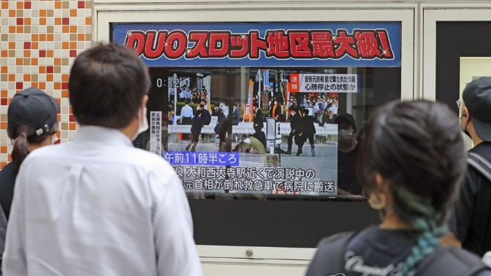 8일 일본 도쿄 거리에서 시민들이 아베 신조 전 총리의 피격 소식을 전하는 TV 뉴스를 보고 있다. 연합뉴스