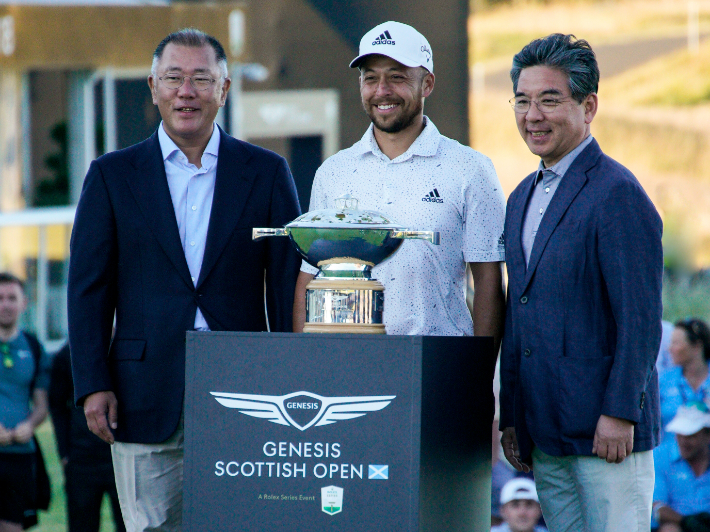  '2022 제네시스 스코티시 오픈'에서 기념 사진을 촬영 중인 현대차그룹 정의선 회장(사진 왼쪽), 우승자 잰더 쇼플리(Xander Schauffele) 선수(사진 가운데), 제네시스 장재훈 사장(사진 오른쪽)의 모습. 제네시스 제공
