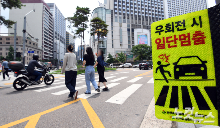 개정 도로교통법 시행을 하루 앞둔 11일 서울시내 한 횡단보도 앞에 관련 현수막이 보행자 안전을 위한 일단 멈춤 표시가 설치돼 있다. 개정된 도로교통법에 따르면 앞으로 운전자는 우회전 시 횡단보도를 건너거나 건너려는 보행자가 있으면 멈춘 다음 보행자가 없으면 지나갈 수 있다. 경찰 관계자는 "우회전 요령과 관련해 핵심은 보행자 확인" 이라고 밝혔다. 황진환 기자