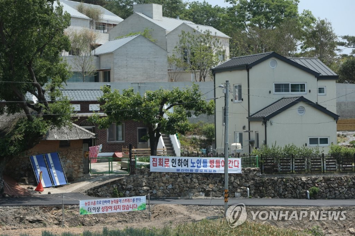 25일 경남 양산시 하북면 지산리 평산마을 문재인 전 대통령 사저 앞에 문 전 대통령 반대단체 집회, 1인 시위에 항의하는 마을주민 현수막이 내걸려 있다. 연합뉴스