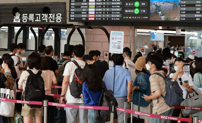 코로나19 확산세가 거세지는 가운데 15일 오전 서울 강서구 김포공항 국내선 청사에서 이용객들이 탑승 수속을 밟고 있다. 연합뉴스