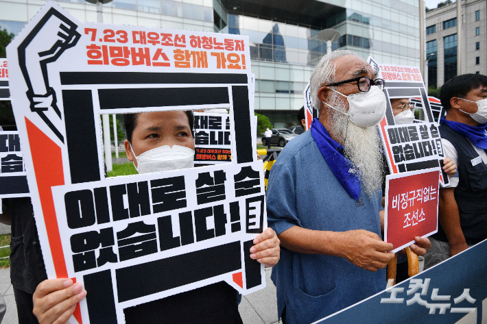 지난 19일 서울 여의도 산업은행 앞에서 열린 7.23 대우조선 하청노동자 희망버스 세부계획 발표 기자회견에서 참석자들이 피켓을 들고 있는 모습. 류영주 기자