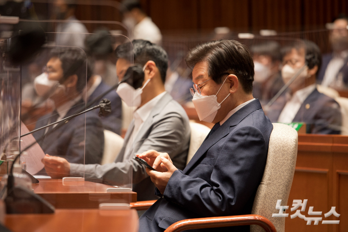 더불어민주당 이재명 의원이 22일 서울 여의도 국회에서 열린 의원총회에서 휴대폰을 확인하고 있다. 윤창원 기자
